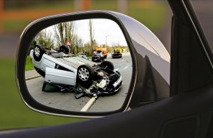 Flipped over vehicle in the mirror of car